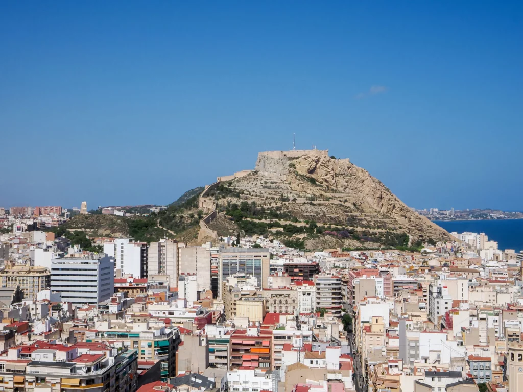 Vista panorámica de Alicante con el Castillo de Santa Bárbara sobre la colina y el mar al fondo