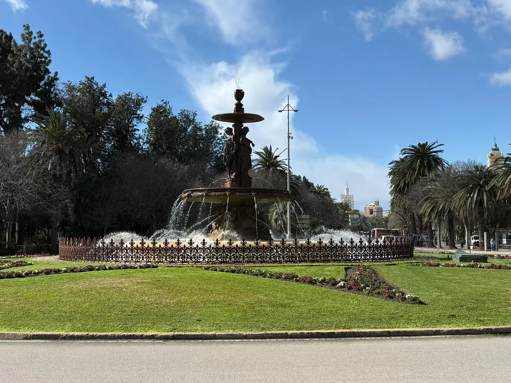 Fuente de las Tres Gracias entre palmeras en el Parque de Málaga